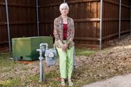 Mary Carpenter, 85, stands outside her home near her gas meter. She is battling Atmos...