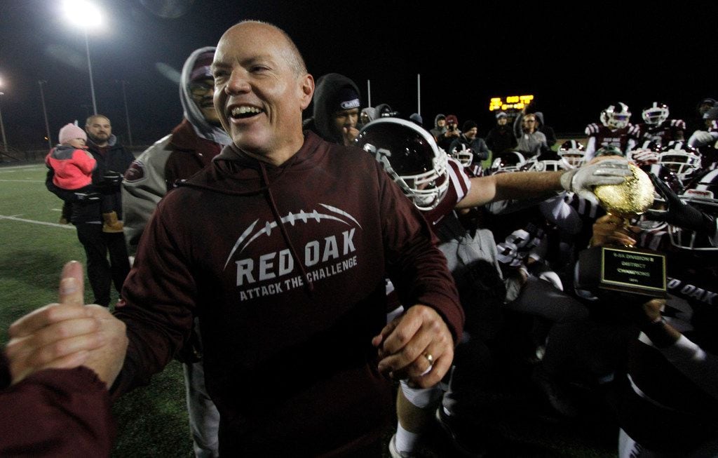 Red Oak head coach Chris Ross receives congratulations as his players marvel at the district...