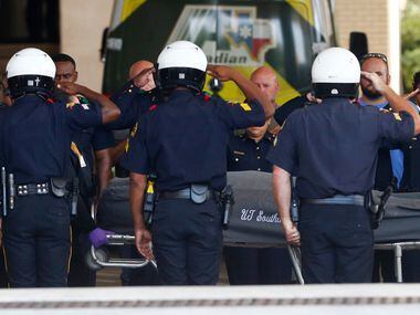 Dallas Police Chief U. Renee Hall and other officers salute Saturday as the body of Senior...