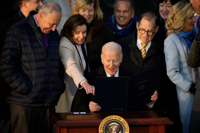 President Joe Biden reacts with House Speaker Nancy Pelosi of Calif., after he signs the...