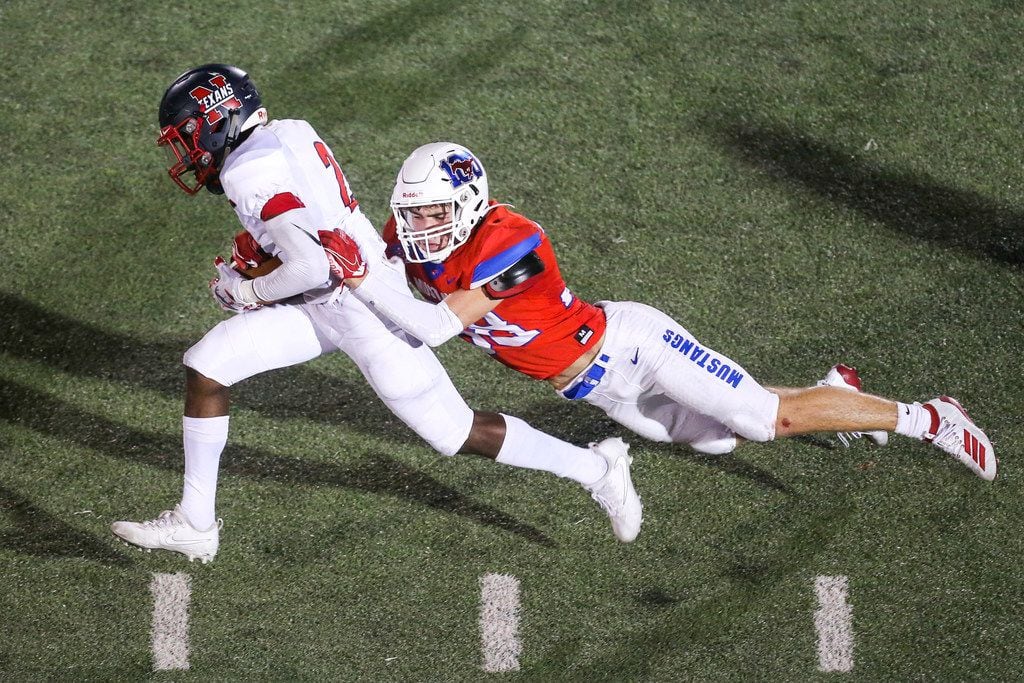 Justin Northwest's Zavion Taylor (2) carries the ball as he is brought down by Grapevine defensive back Dylan Hohenberger (38) during the first half of a high schools football game at Mustang-Panther Stadium in Grapevine, Texas on Thursday, September 12, 2019. (Shaban Athuman/Staff Photographer)