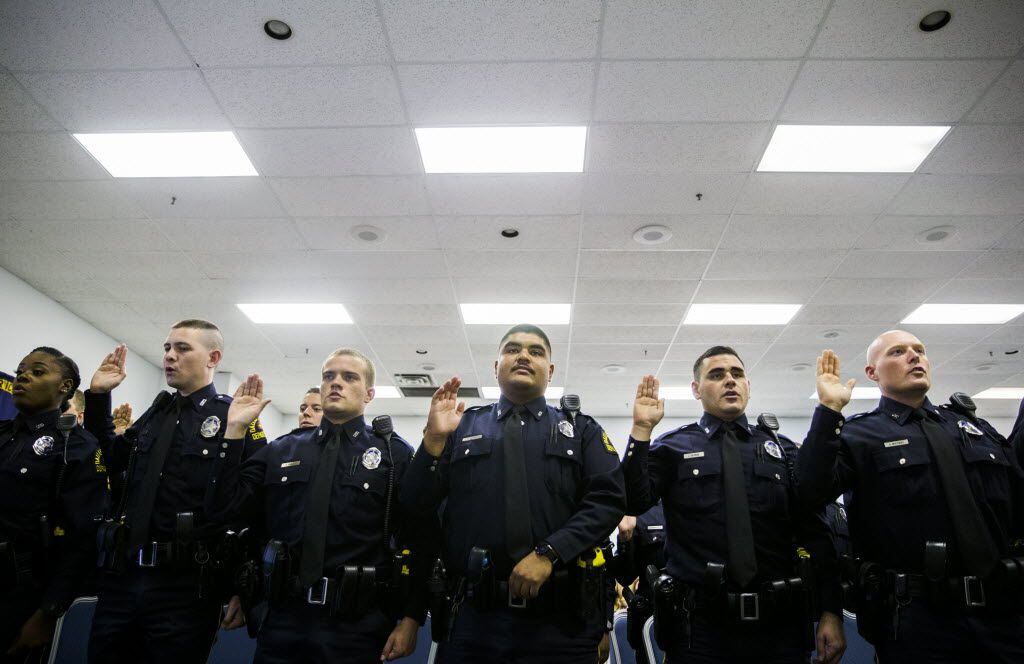 File - New Dallas police officers take an oath after receiving their badges  (Ashley...