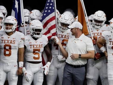 Texas head coach Tom Herman, center, prepares to takes the field with quarterback Sam Ehlinger (11) and the rest of the team during the first half of an NCAA college football game against Rice Saturday, Sept. 14, 2019, in Houston.