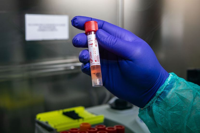 A lab worker handles a vial during a swab test process in Milan, Italy, on Thursday.