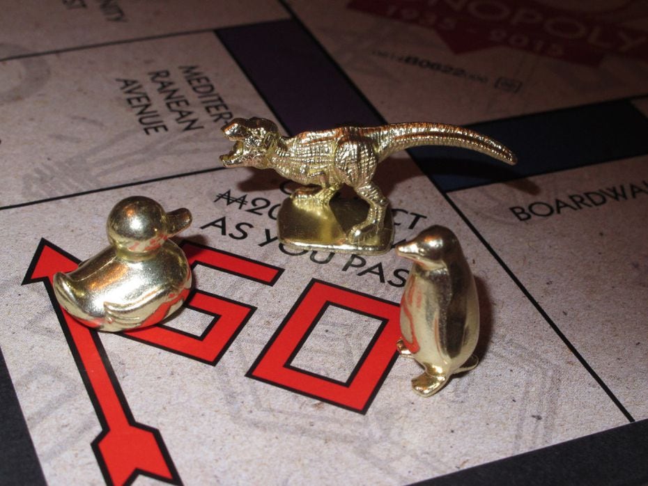 This 2017 photo shows three new tokens that fans from around the world voted into upcoming editions of the Monopoly: a duck, a T-Rex dinosaur and a penguin. 