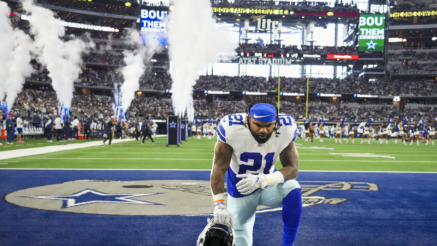Dallas Cowboys running back Ezekiel Elliott (21) kneels on the field before an NFL football...