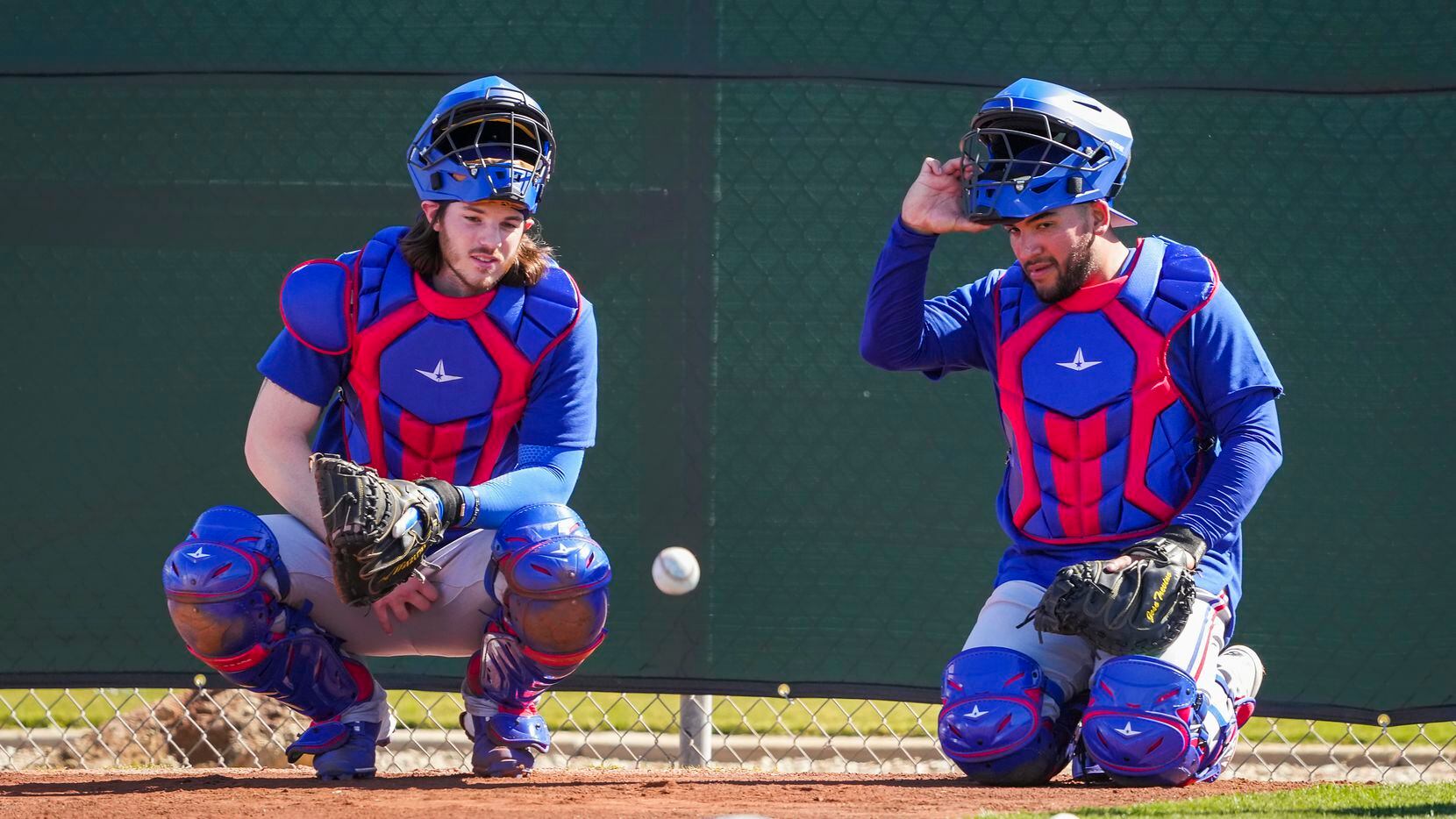 Texas Rangers catchers Jonah Heim (left) and Jose Trevino wait their turn in a defensive...