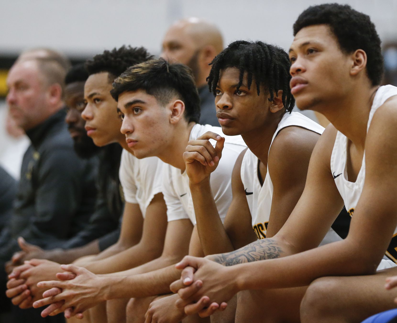Fossil Ridge High School players watch as their teammate shoots a free-throw during the...