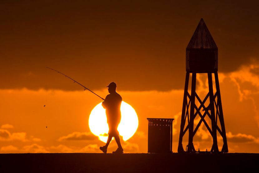 En esta imagen del 14 de julio de 2016, un pescador se prepara para lanzar su línea al...