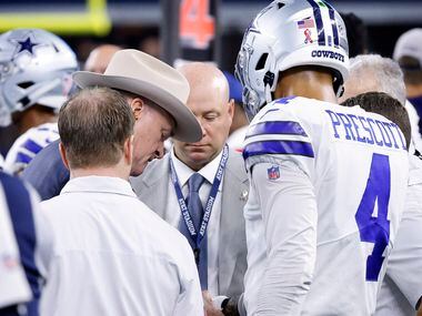 Dallas Cowboys quarterback Dak Prescott (4) has his throwing hand looked at by team...