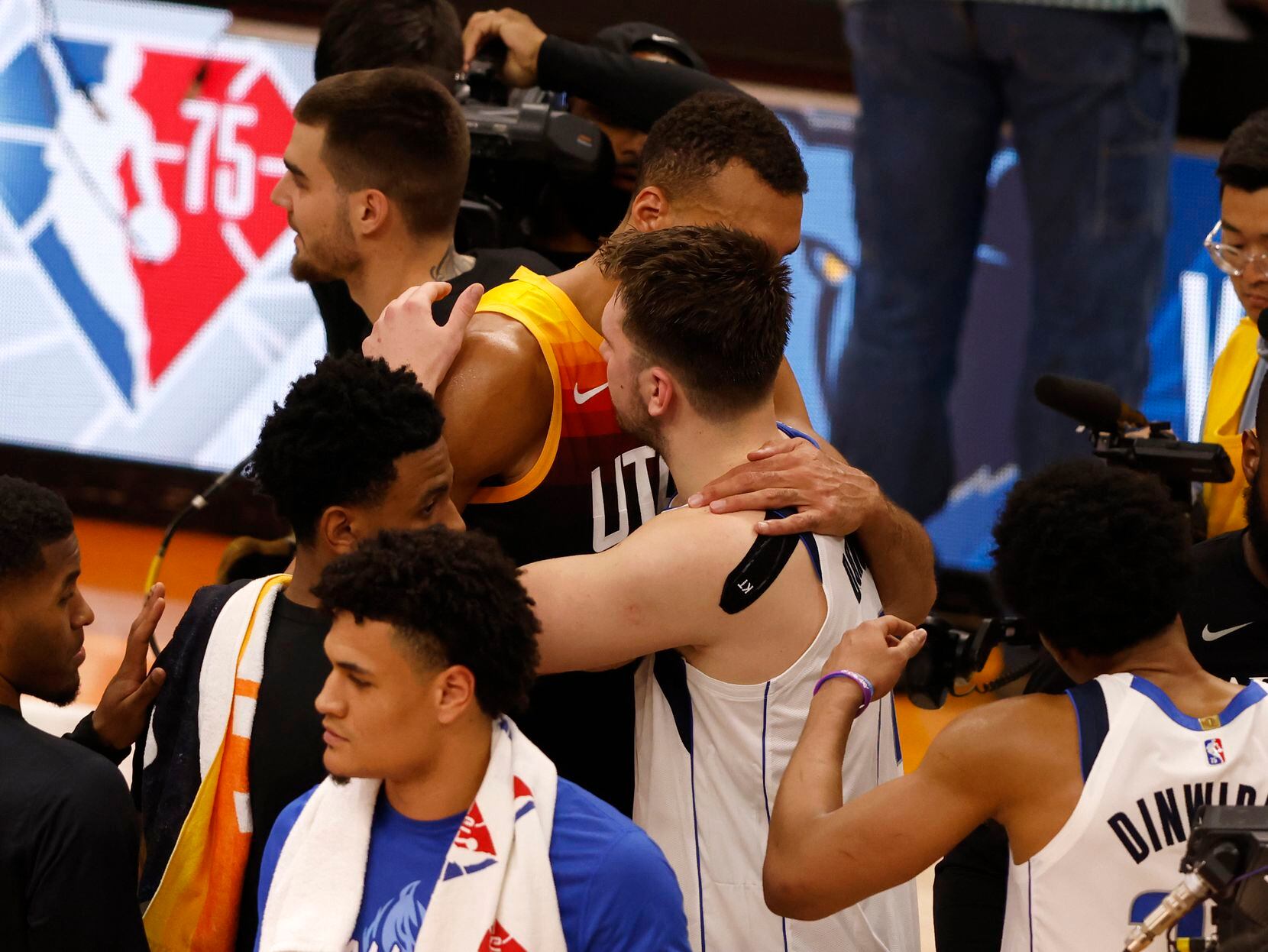 Dallas Mavericks guard Luka Doncic (77) hugs Utah Jazz center Rudy Gobert (27) after game 6...