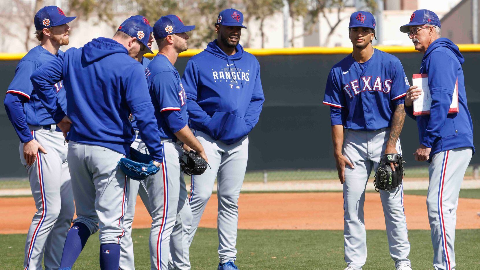 Texas Rangers pitching coach Mike Maddux, right, talks the players during a spring training...
