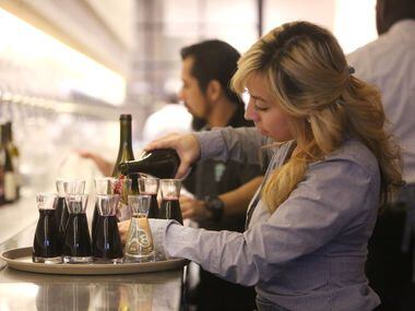 Bartender Christina Valencia pours wine at Sixty Vines, a new wine-centric restaurant in...