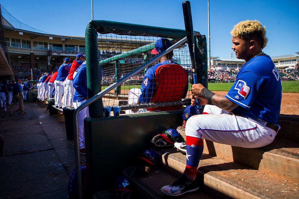 Texas Rangers outfielder Willie Calhoun sits in the dugout before hitting during the fourth...
