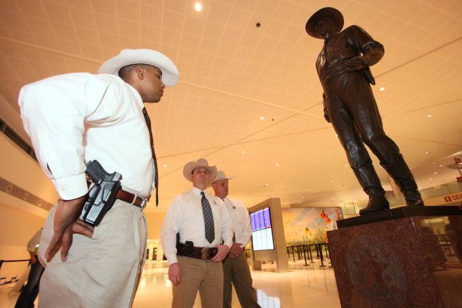 Texas Ranger David Armstrong, left, looks over the re-installed One Riot, One Ranger statue...