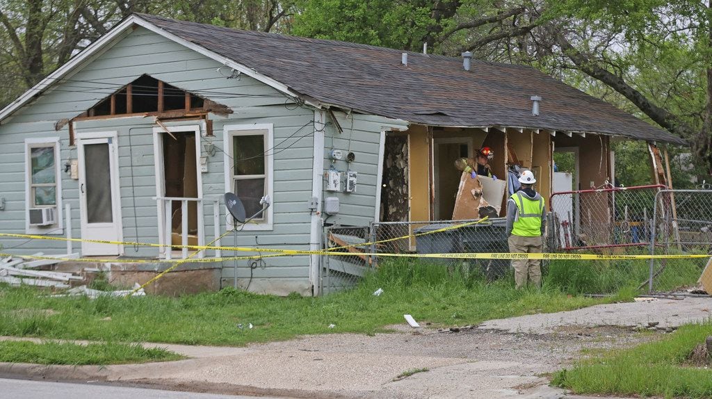 Officials investigate a house explosion at 3700 Spring Avenue in Dallas, near Fair Park, on...