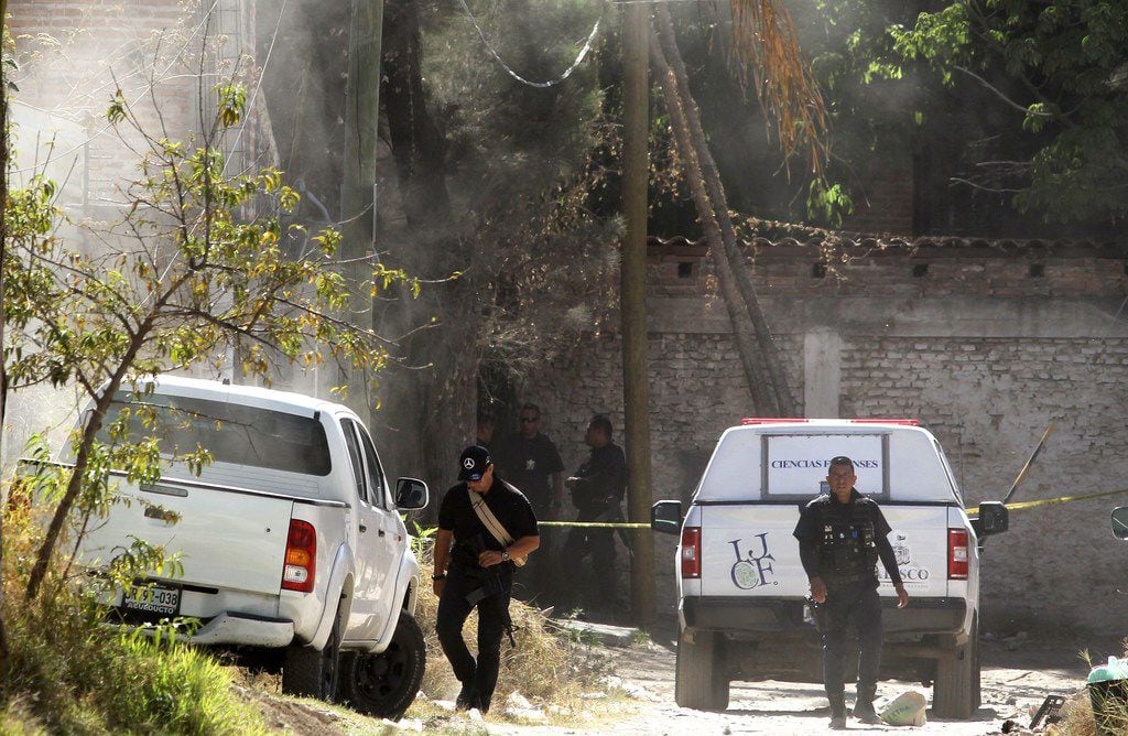 Forensic personnel and police officers are seen outside a criminal hideout where eight...