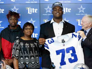 Dallas Cowboys first round draft pick Tyler Smith of Tulsa, center, poses for a photo with...