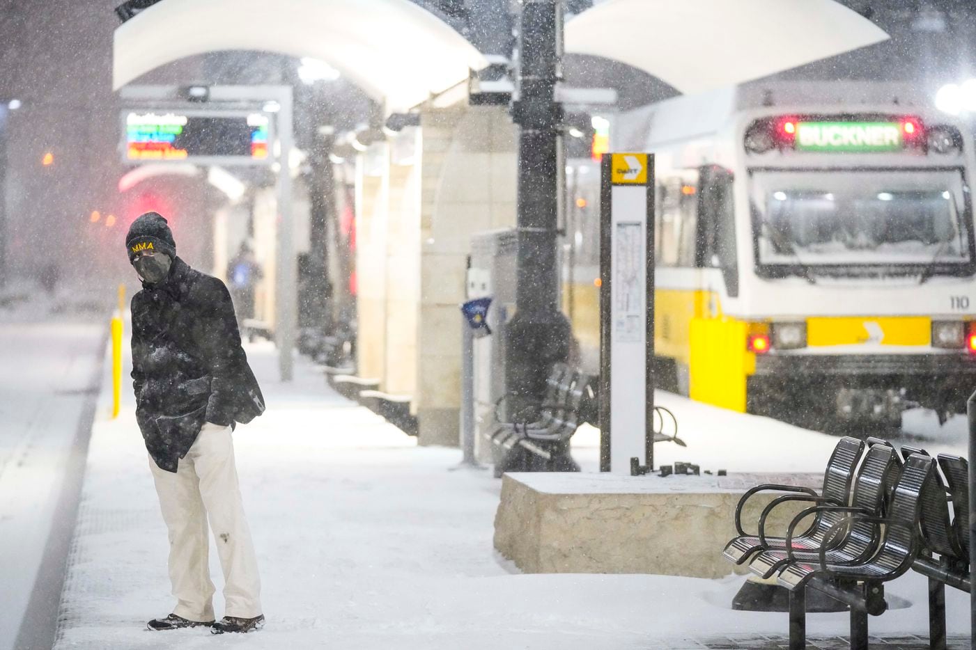 Victor Escamilla looks down the tracks as people wait in driving snow at the Pearl/Arts District station as a winter storm brings snow and freezing temperatures to North Texas on Sunday, Feb. 14, 2021, in Dallas.  DART suspended all rail operations Sunday night.