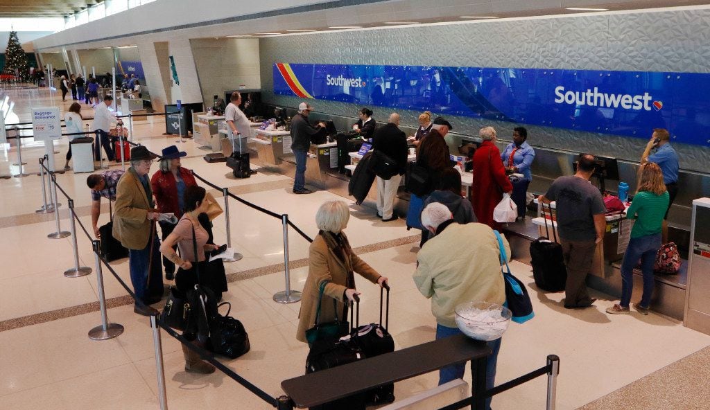 Southwest Airlines passengers wait in line to check in at Dallas Love Field on Thursday,...