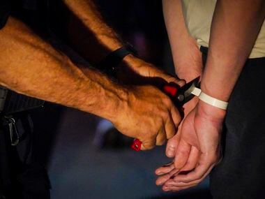 Protesters have their disposable cuffs removed as they are released outside the Frank...