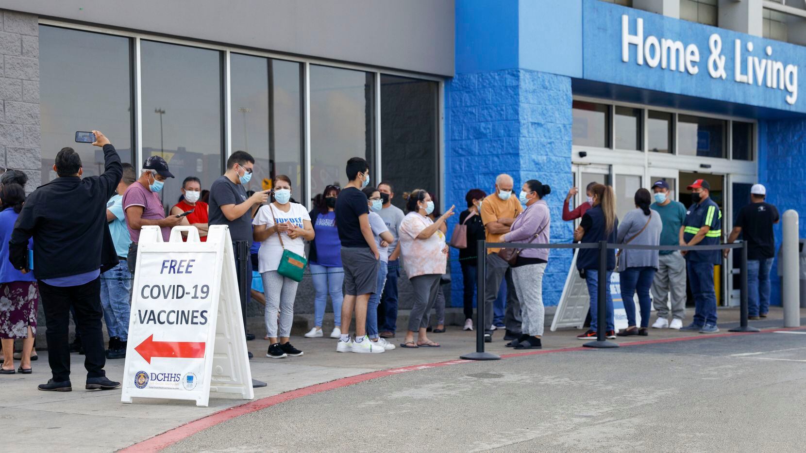 People wait in line at a COVID-19 vaccination clinic at the Walmart on North Cockrell Hill...