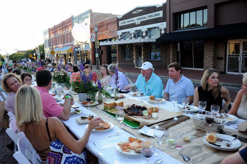 Guests eat and drink at an outdoor table during Night Out on 15th Street in downtown Plano.