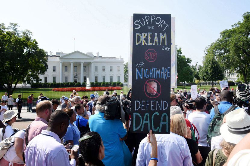 Protesters held up signs during a rally supporting Deferred Action for Childhood Arrivals,...