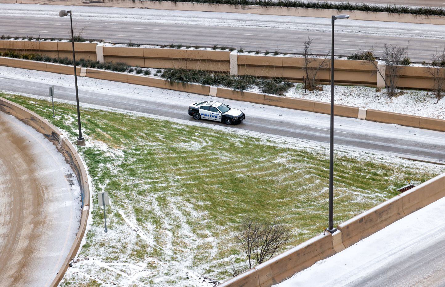 A Dallas police vehicle drives along an access road of U.S. 75 in Dallas on Wednesday, Feb....