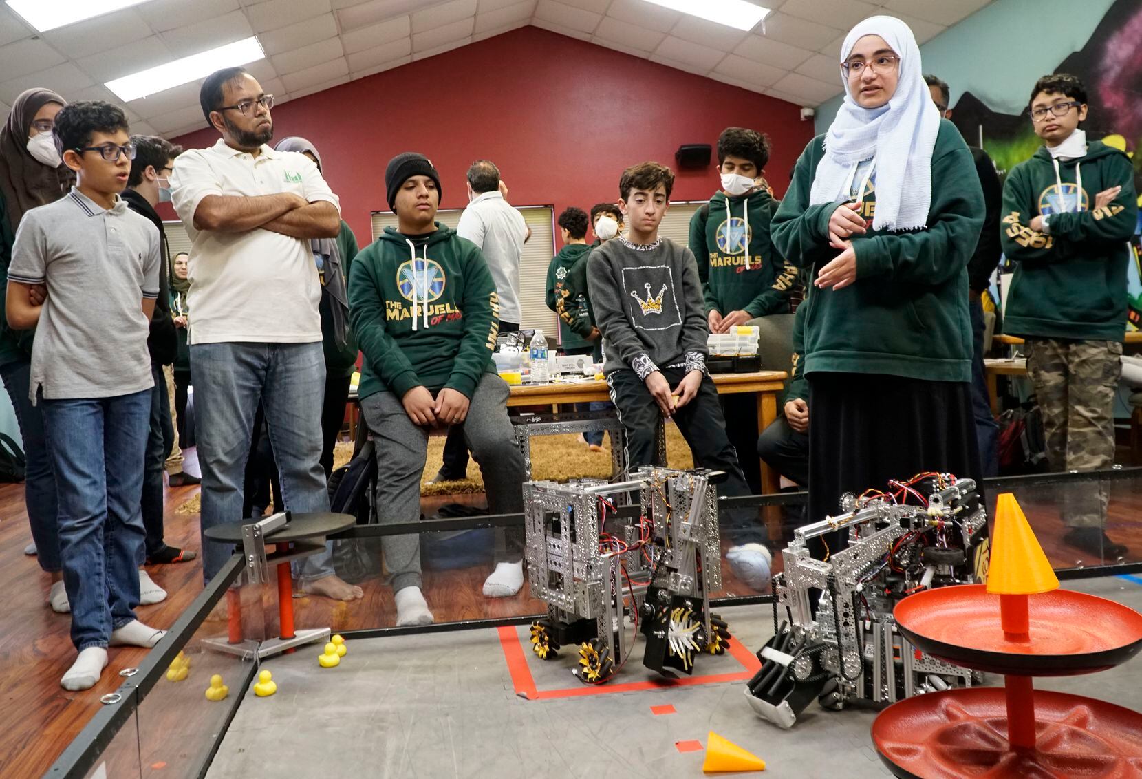 Roofaida Hanoun, 16, speaks to robotics team members about the process of building a robot...