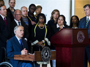 Texas Governor Greg Abbott (left) and Dallas Mayor Mike Rawlings (right) speak during a...