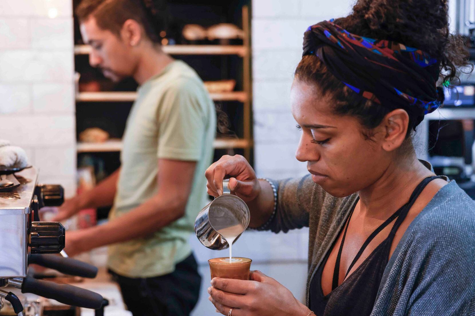 Staycation Coffee owner Nicole Gregory, front, makes a beverage as her brother Solomon...
