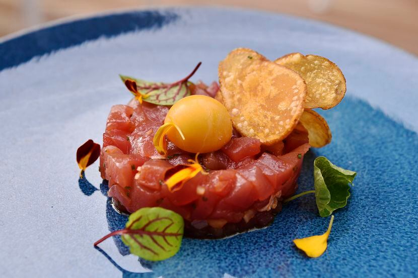 Tuna tartare, which is an appetizer, is served with radish, soy-lime vinaigrette and sea...
