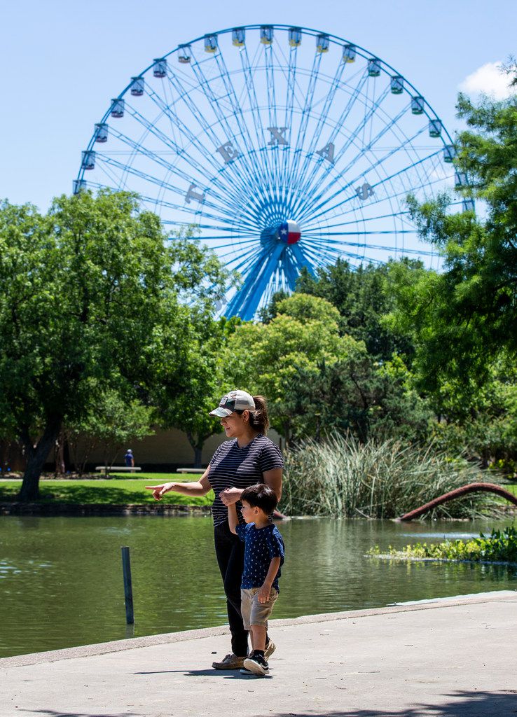 Under the Texas Star Ferris Wheel, Veronica Zubia and her son Arturo look at the number of...