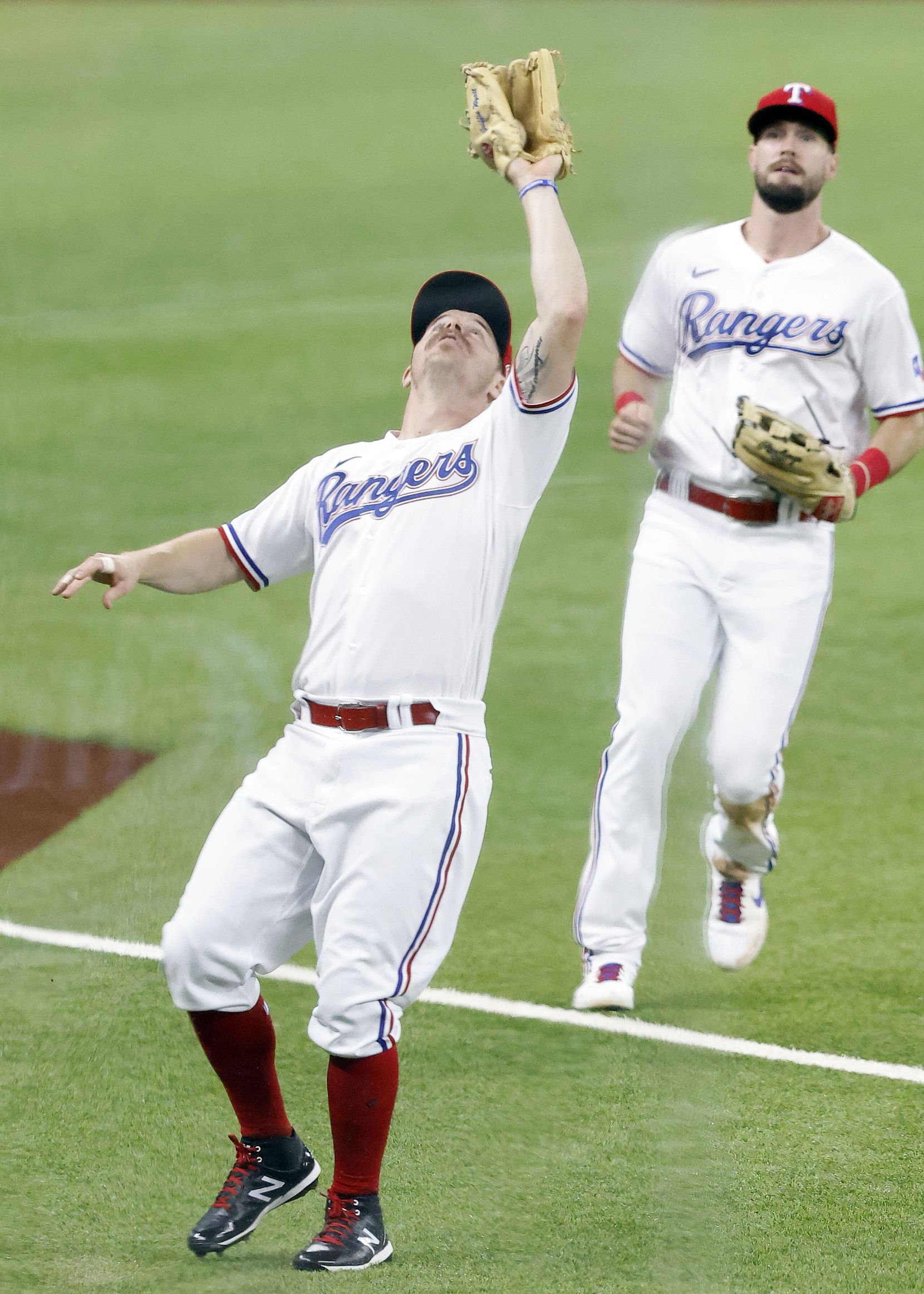Texas Rangers third baseman Brock Holt (16) catches a fly ball in foul territory by Los Angeles Angels batter Scott Schebler (44) during the ninth inning at Globe Life Field in Arlington, Texas, Wednesday, April  28, 2021. (Tom Fox/The Dallas Morning News)