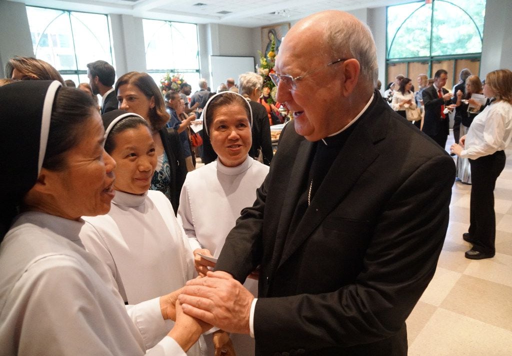 Sisters Mary Ngo, Teresa Nguyen, and Teresa Bui congratulate Bishop Kevin Farrell after his...