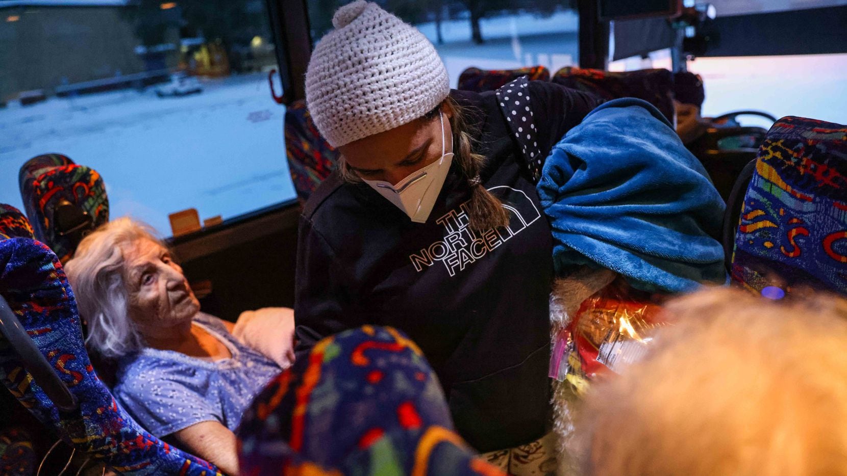 Marleny Almendarez, 38, makes her way into the bus that serves as a warming center located...