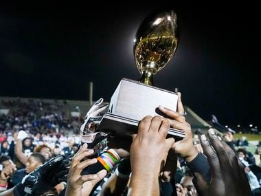 South Oak Cliff celebrate with the game trophy after a victory over Lubbock Cooper in a...