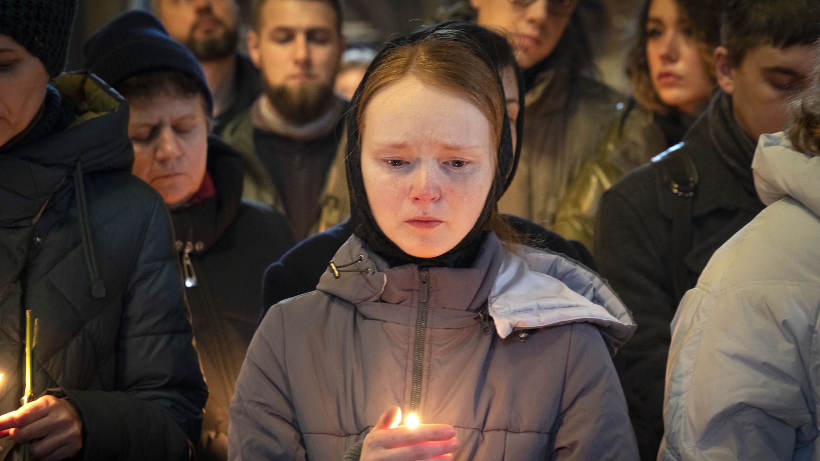 Relatives and friends pray at a coffin of Gennadiy Afanasyev, Ukrainian army volunteer and...