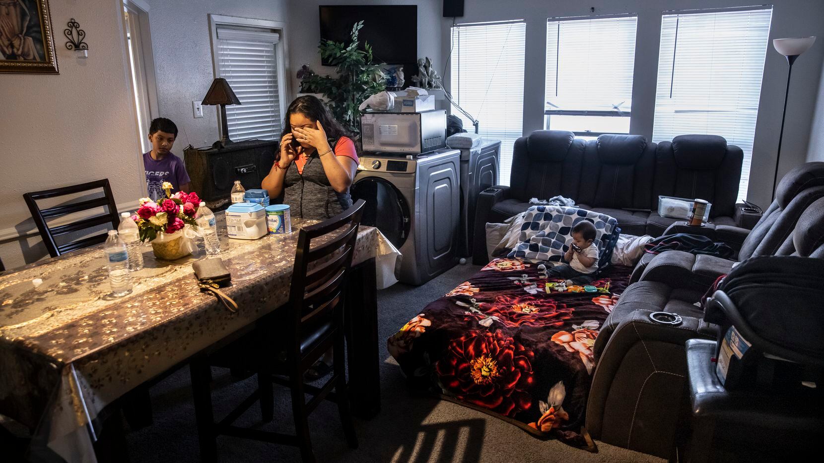 Maria Magarin takes a phone call while standing in the living room of her apartment at The...