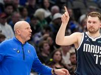 Dallas Mavericks head coach Jason Kidd talks with guard Luka Doncic (77) as he checks into...