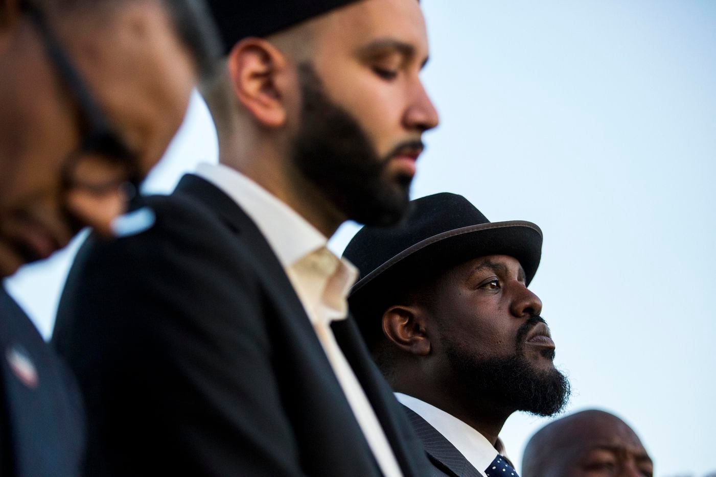 Dr. Michael W. Waters (right) and Imam Omar Suleiman (center) listen to a speaker during the...