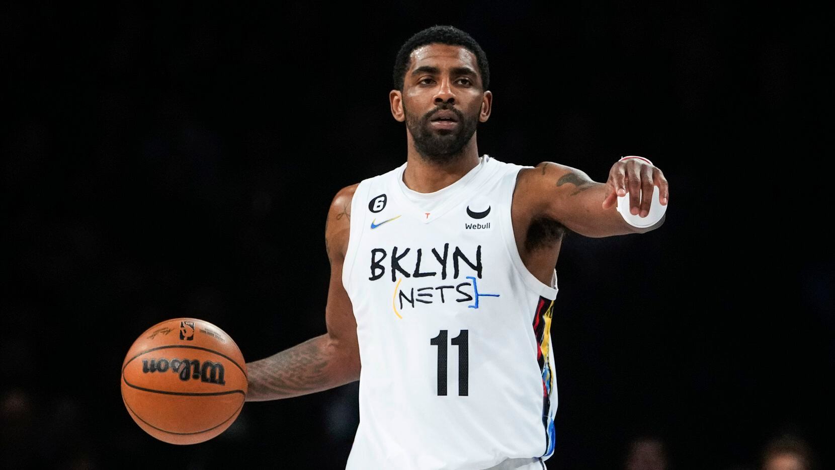Brooklyn Nets' Kyrie Irving gestures to a teammate during the first half of an NBA...