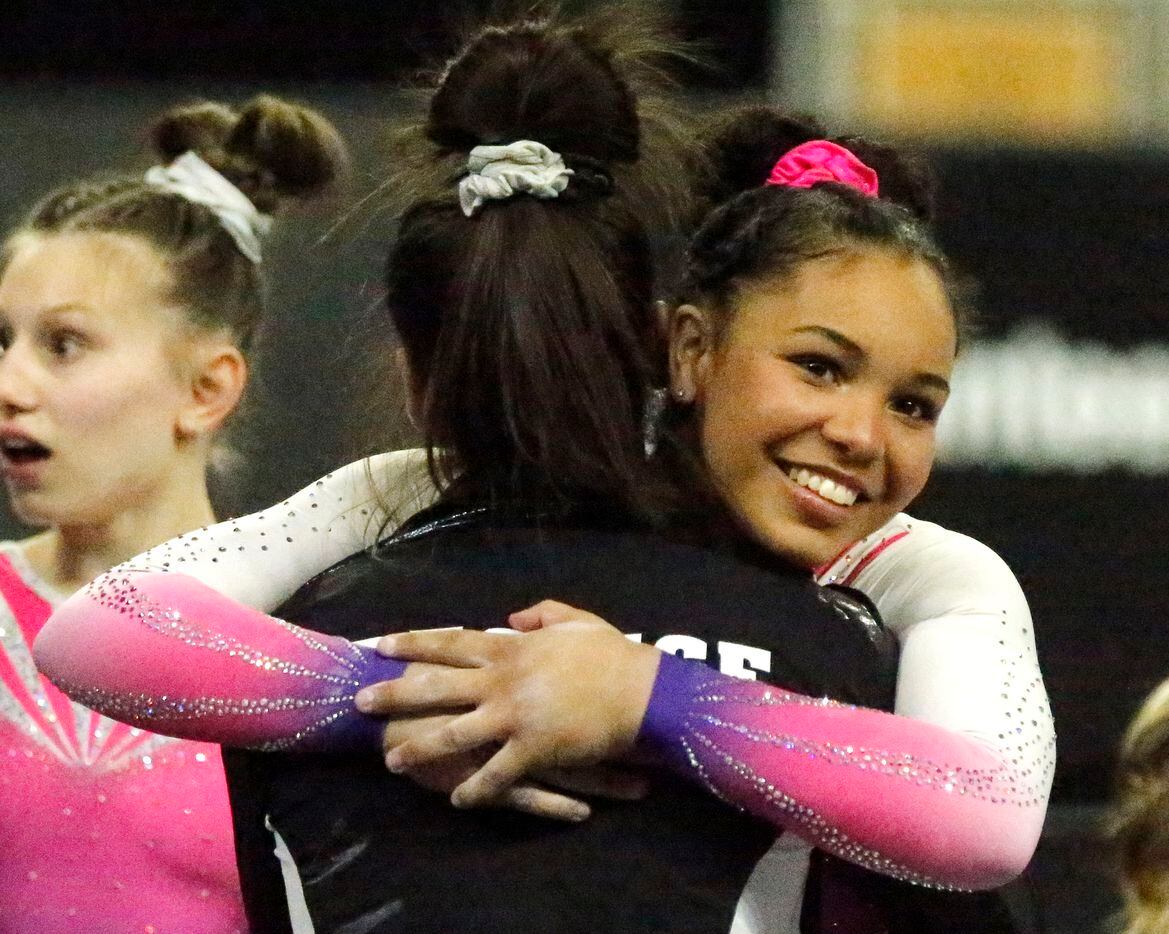 Konnor McClain with WOGA Gymnastics in Plano, embraces a competitor after winning first...