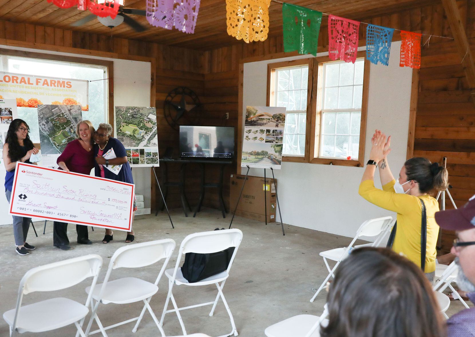 A check of $100,000 from Santander Bank is presented at the reveal party for the design of...