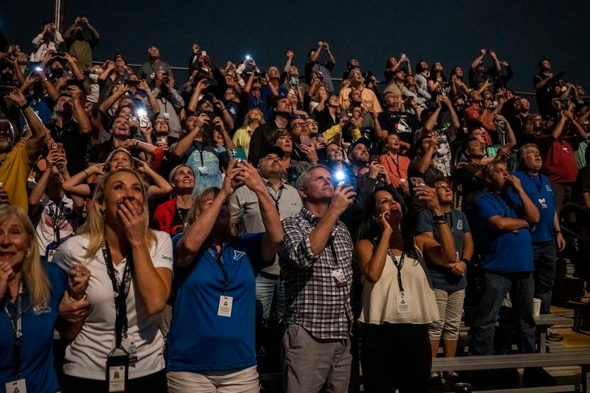 Gente observa el lanzamiento del nuevo cohete lunar de la NASA desde el Centro Espacial...