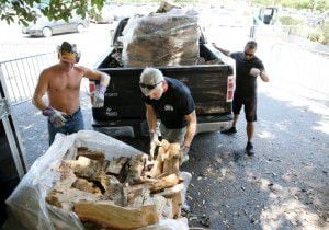  Tony Robbins' fire team loaded unused wood on Friday, the day after the fire walk. (Andy...