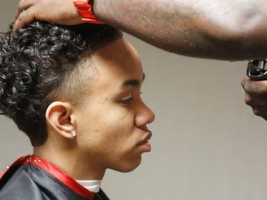 Tai Jordan of Seattle receives a new hair cut from Rashad German at the conference. German,...