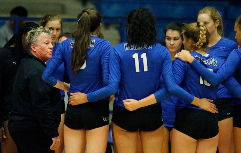 Hebron coach Karin Keeney (left) addresses her team during a timeout in a match against...
