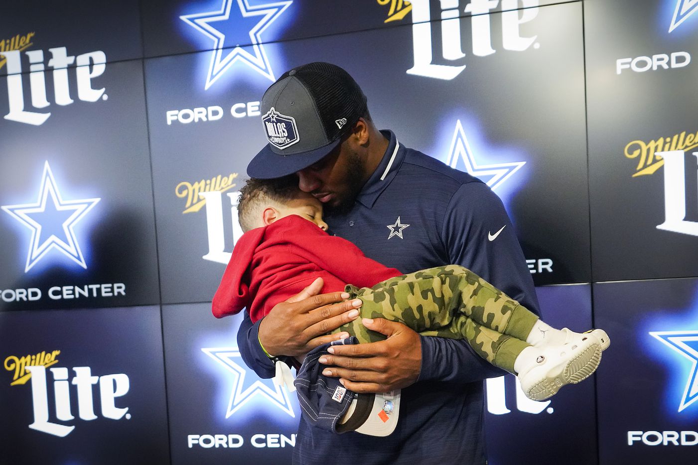 Dallas Cowboys first-round draft pick Micah Parsons holds his sleeping son Malcolm, 3,...